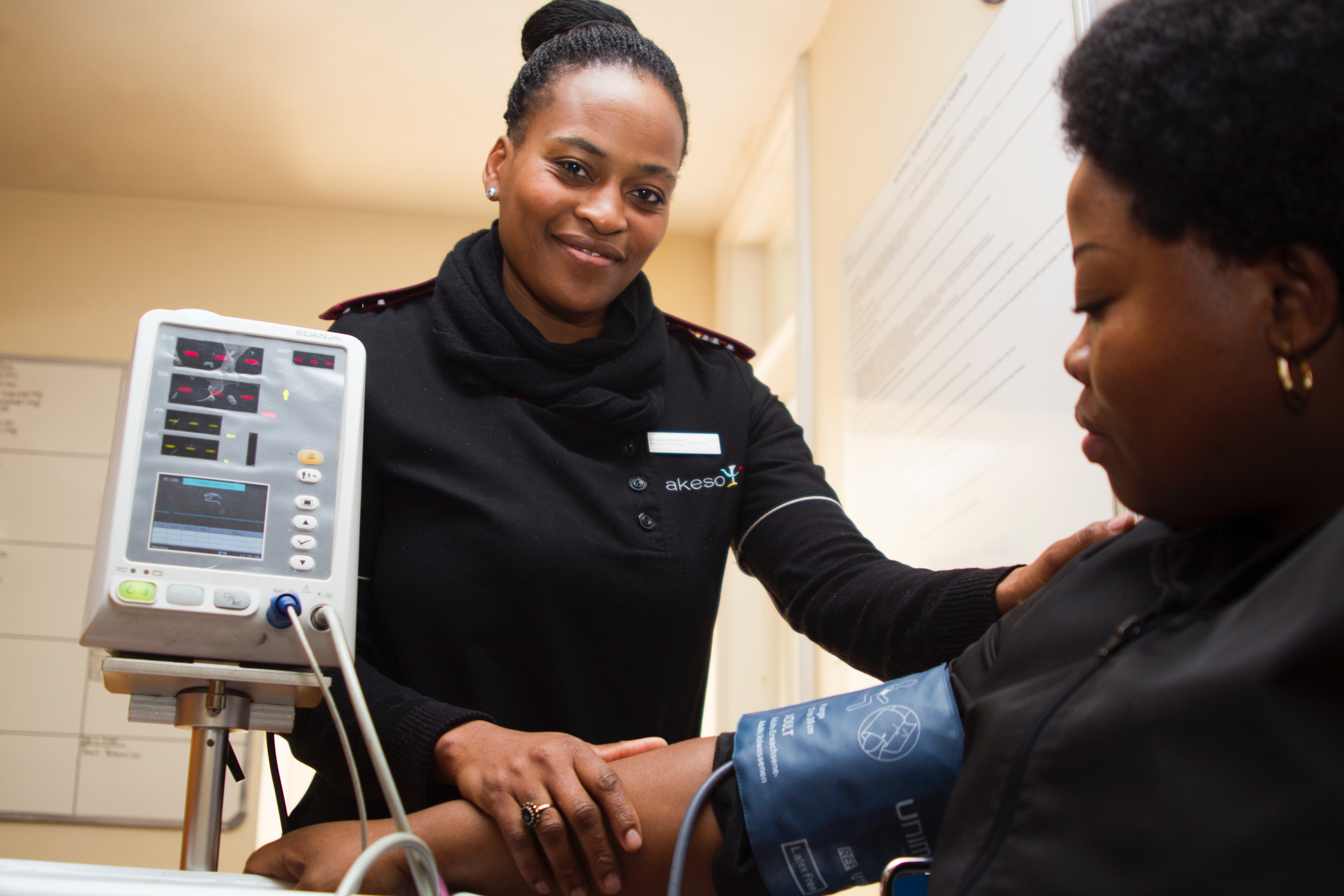 Woman taking blood pressure of a patient